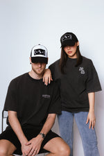 Load image into Gallery viewer, A Male and Female Model wearing Deadstock Clo Conquerer Trucker Hat Black

